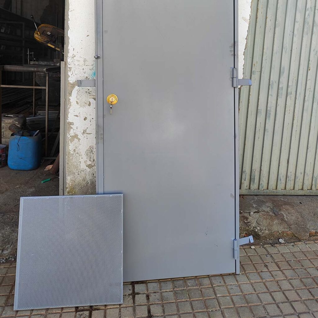 Puerta metálica gris instalada en nave industrial